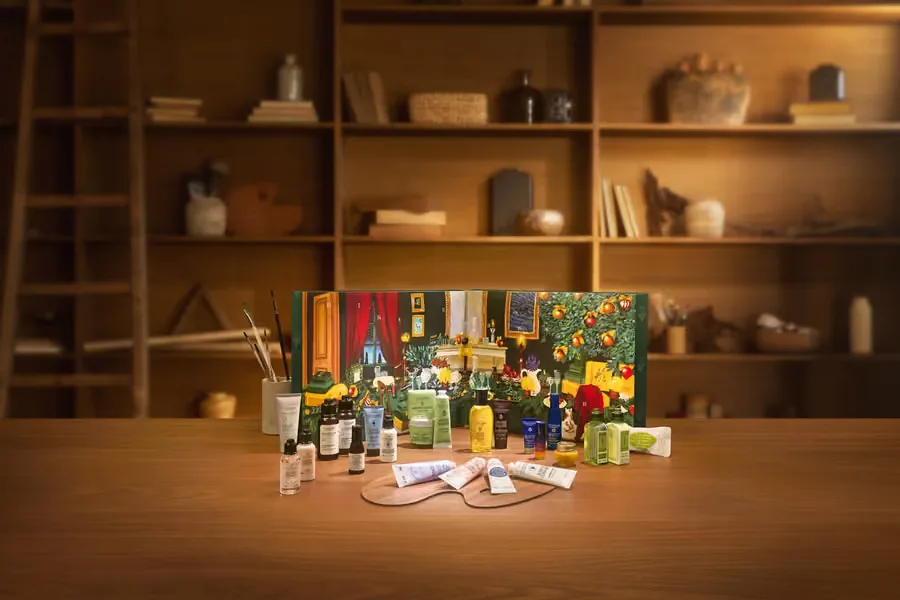 Geöffneter L'Occitane Adventskalender 2026 in Grün mit Pflegeprodukten auf einem Holztisch